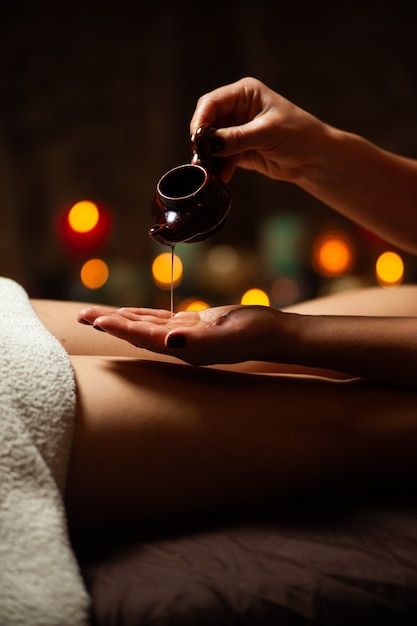 Close de um terapeuta servindo oleo para um tratamento de spa Foto Premium
